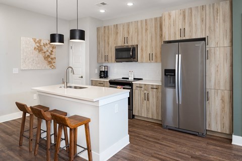 A kitchen with a white island and wooden cabinets.