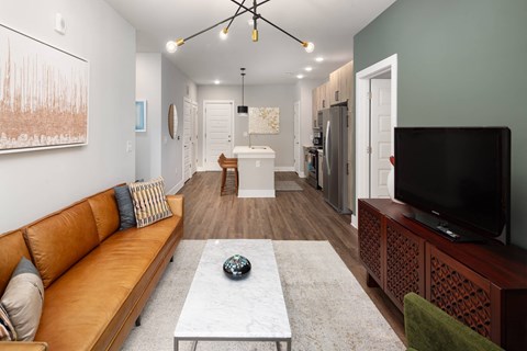 A living room with a brown leather couch and a white coffee table.