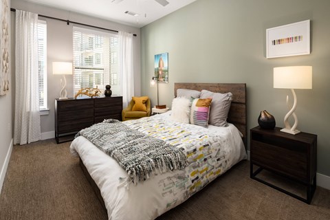 A bedroom with a bed, nightstands, and lamps.