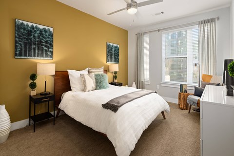 A bedroom with a large bed and a ceiling fan.