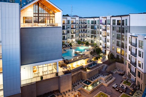 A modern building with a pool in the courtyard.