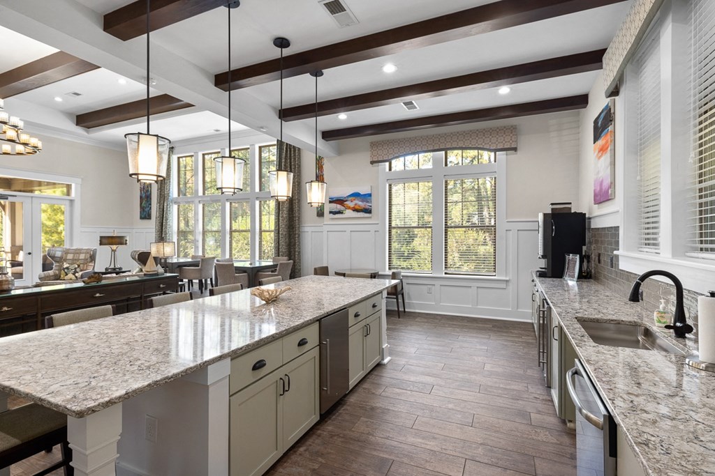 A kitchen with a large island and pendant lights.