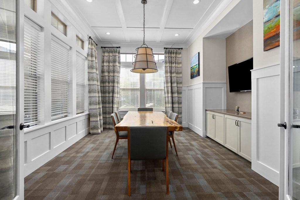 A dining room with a wooden table and chairs.