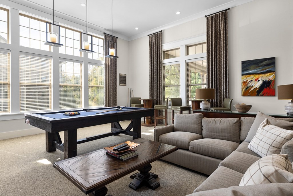 A living room with a pool table and a couch.