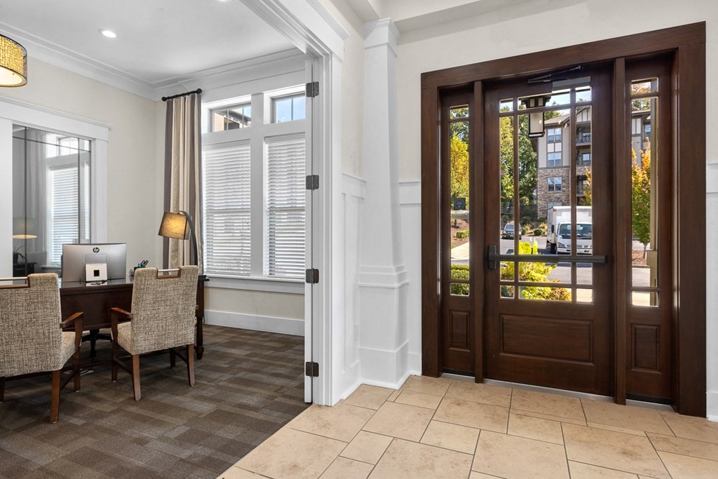 A room with a brown door and a table with chairs.