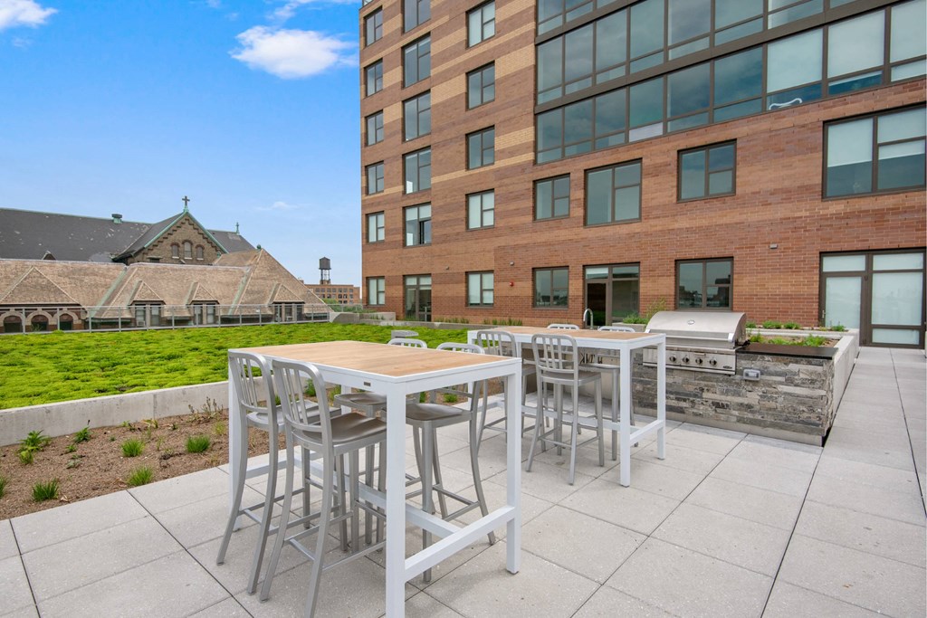 A patio with a table and chairs is in front of a modern building.