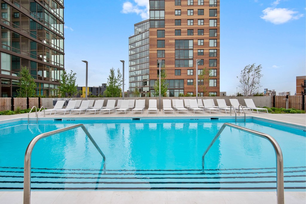 A swimming pool with a metal railing in front of a building.