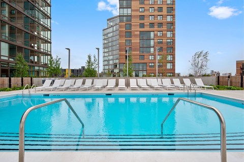 A swimming pool with a metal railing in front of a building.