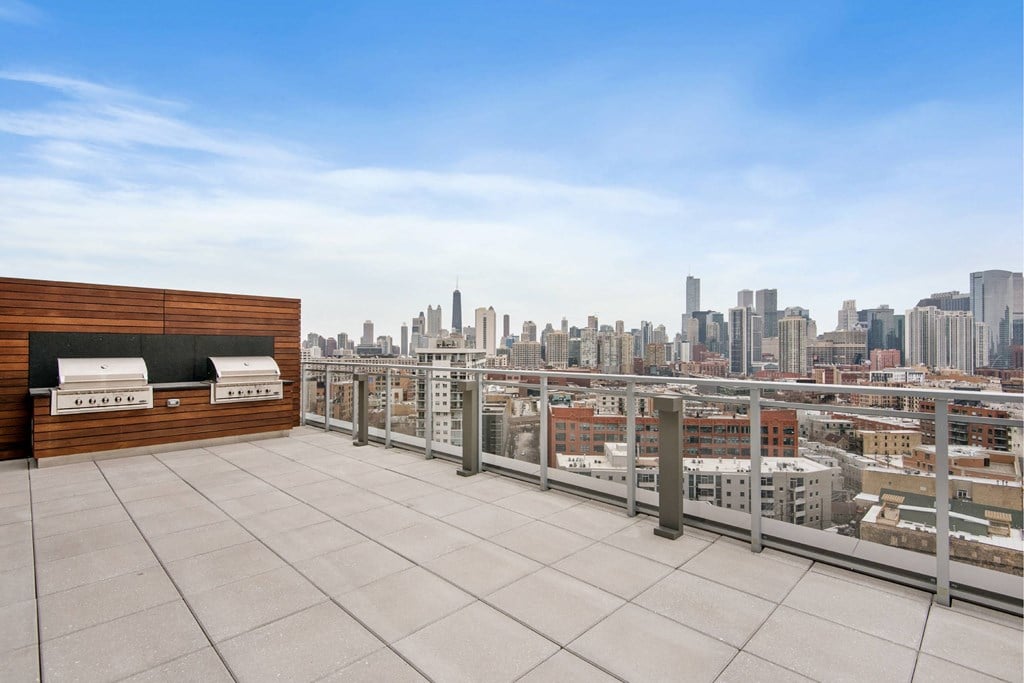 A rooftop patio with a view of a city skyline.