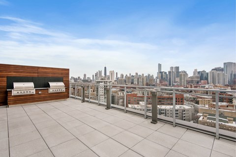 A rooftop patio with a view of a city skyline.