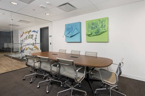 A conference room with a long table and chairs.