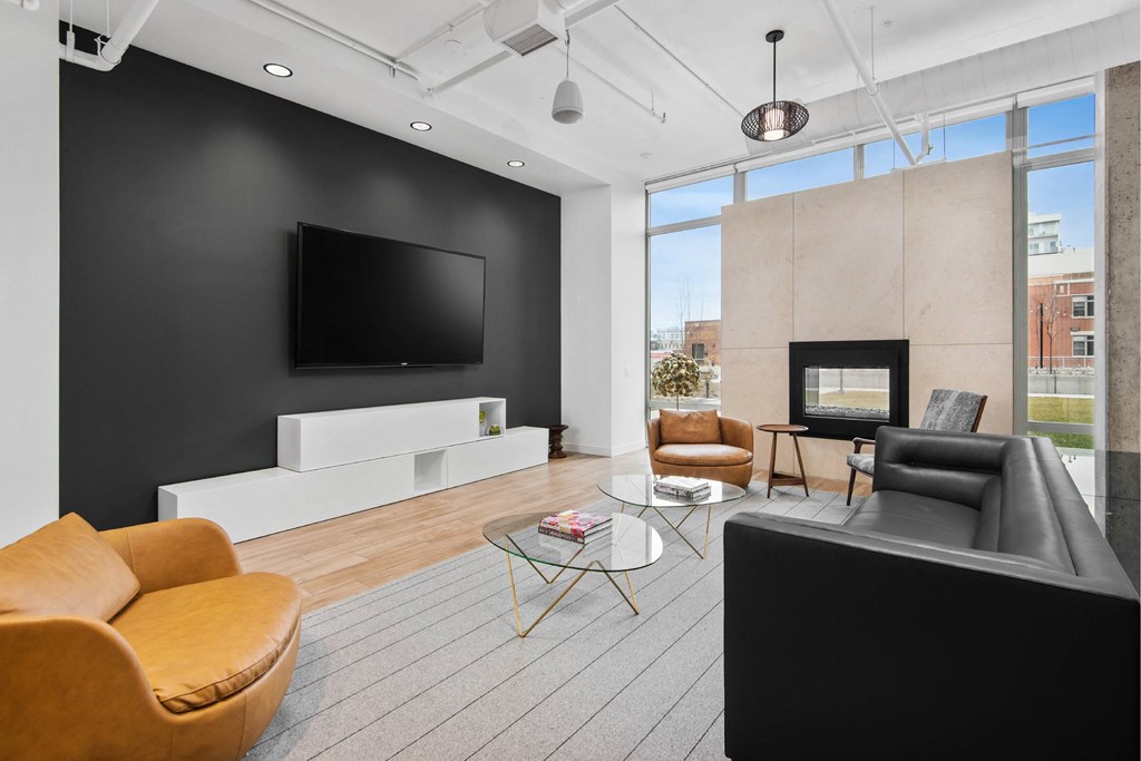 A modern living room with a large television and comfortable seating.