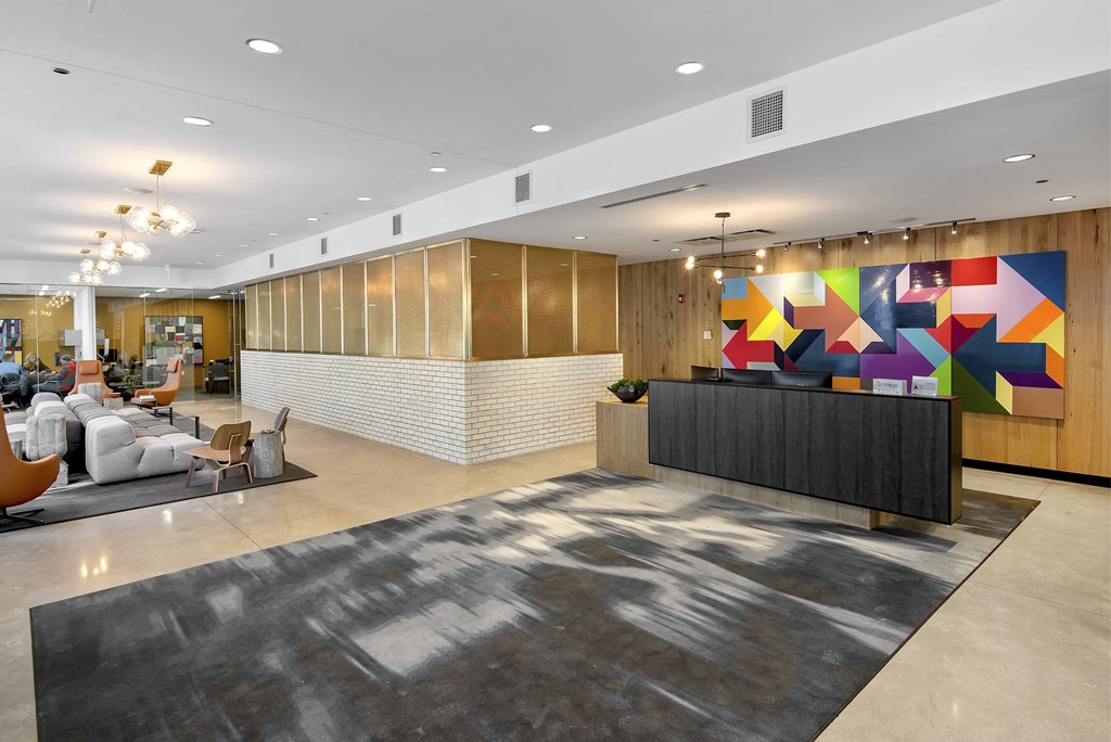 A reception area with a large rug and a colorful mural on the wall.