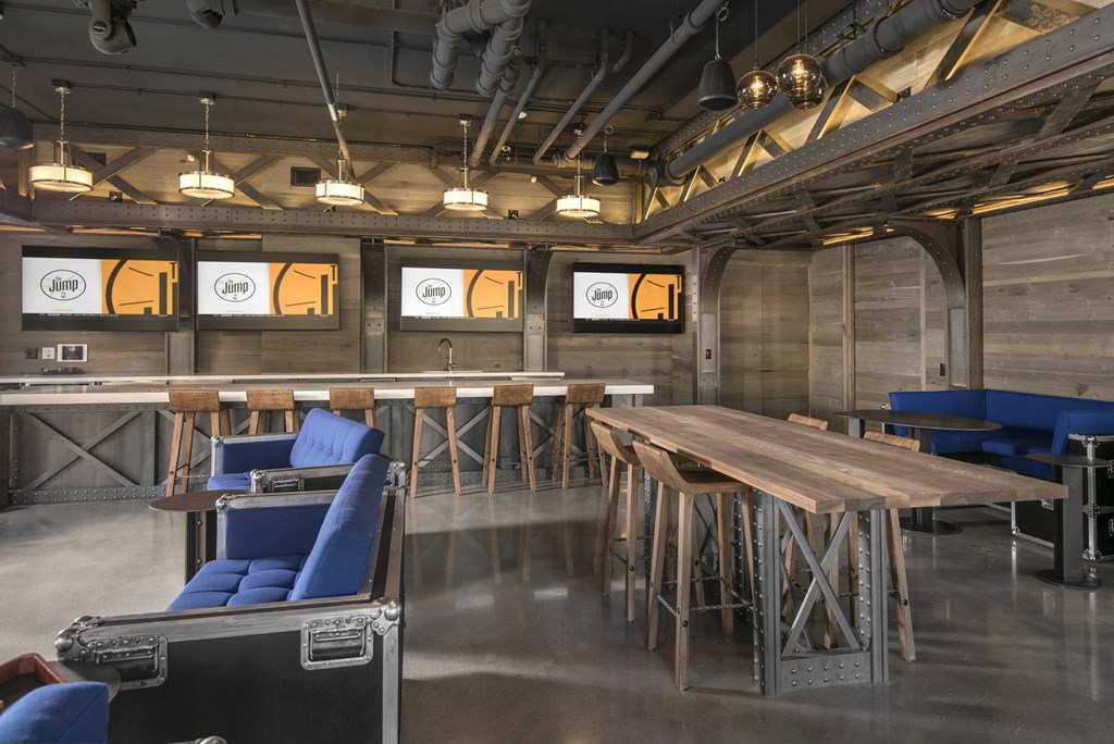 A room with a long wooden table and blue chairs.