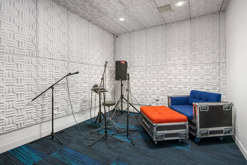 A room with a microphone, a speaker, and a couple of chairs.