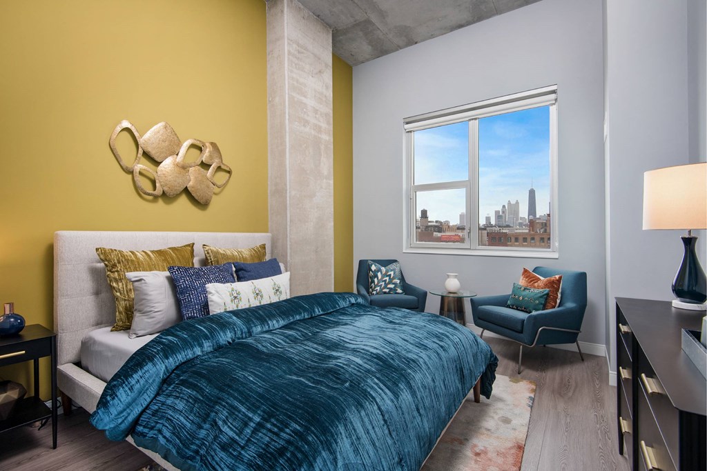 A bedroom with a bed, a chair, and a decorative wall piece.