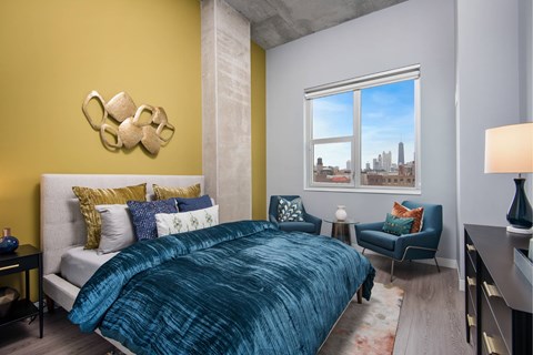 A bedroom with a bed, a chair, and a decorative wall piece.
