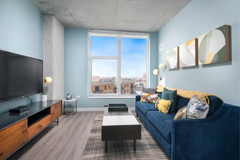 A living room with a blue couch and a television.