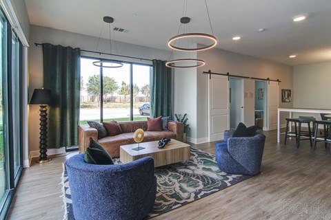 A living room with a blue chair and a lamp.