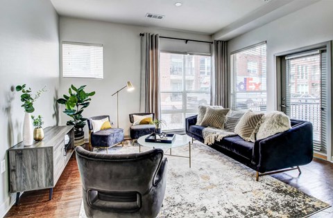 A living room with a black couch and a grey chair.