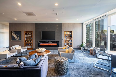 A modern living room with a dark blue sofa and a fireplace.