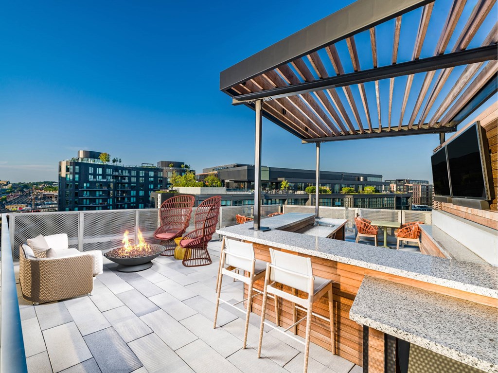 A rooftop patio with a fire pit and seating area.