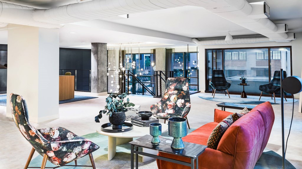 A modern living room with a red sofa and a black chair.