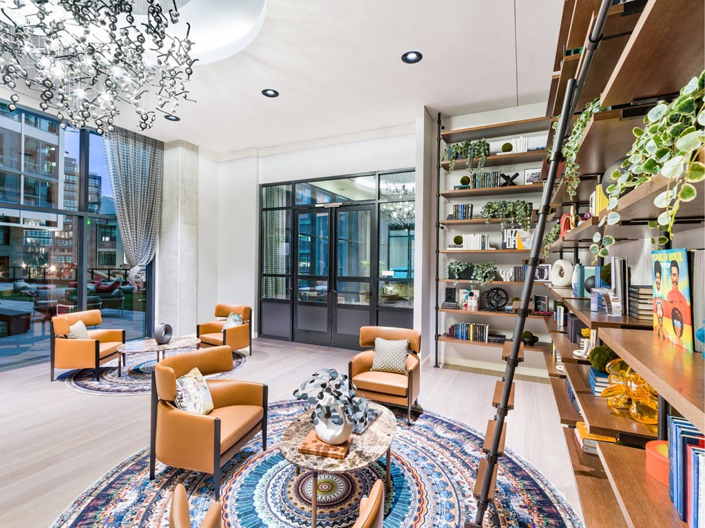 A living room with a large rug and a chandelier.
