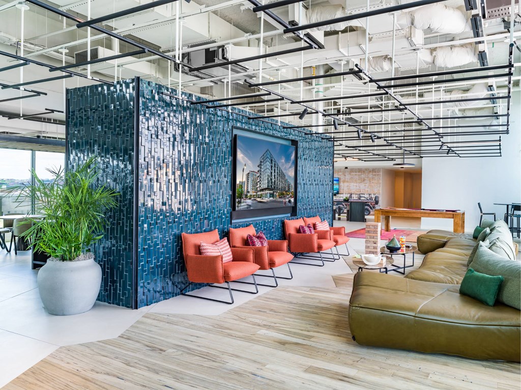 A modern living room with a blue wall and a large painting.