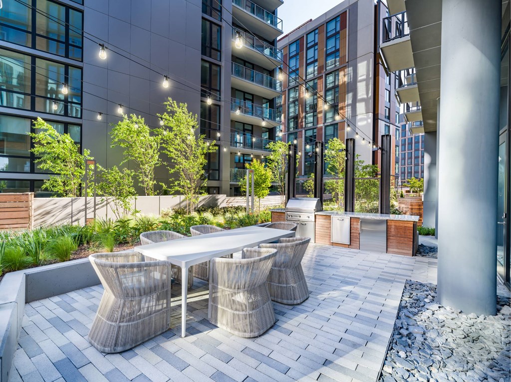 A modern outdoor seating area with a table and chairs.