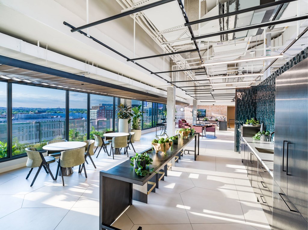 A modern open space with tables and chairs and a view of the city.