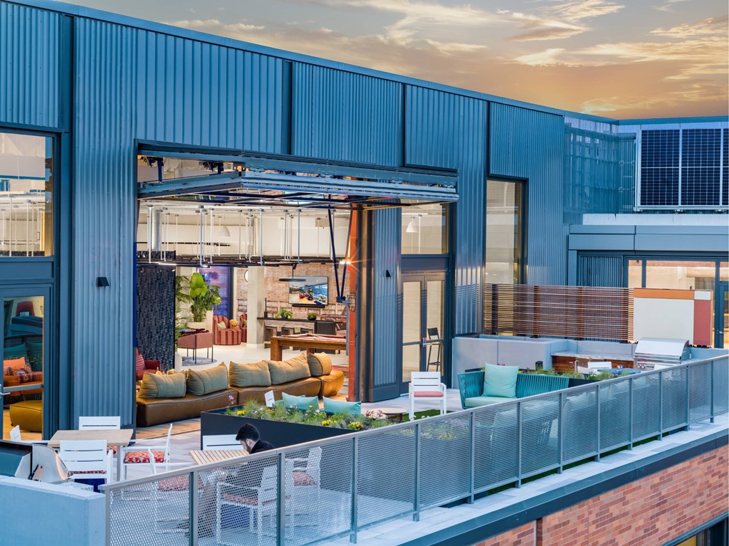 A modern building with a balcony overlooking a living area.