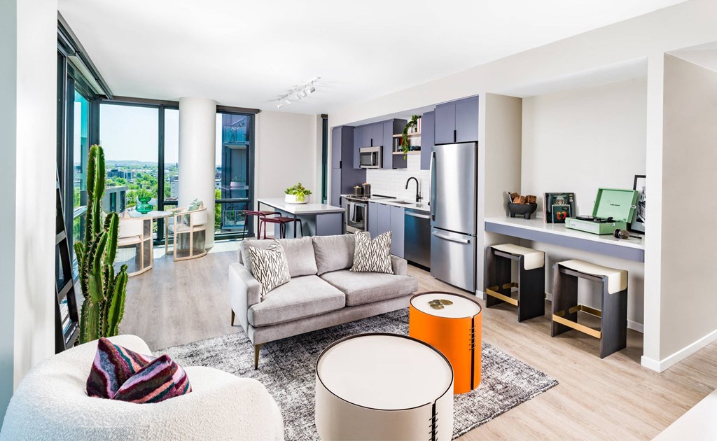 A modern living room with a couch, a chair, a table, and a cactus.