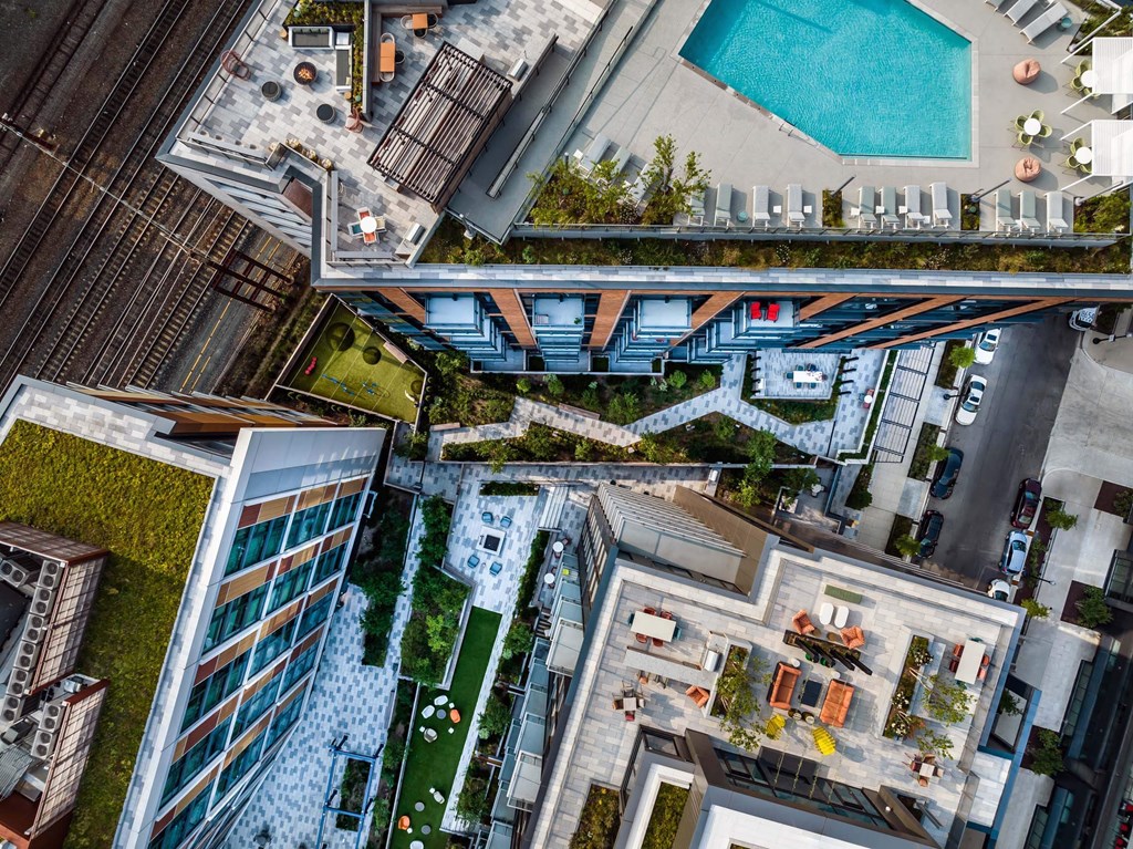 A bird's eye view of a modern building with a pool and a bridge.