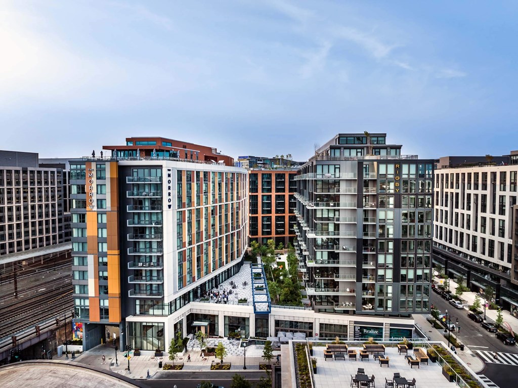 A modern building complex with a variety of different buildings and a plaza in the middle.