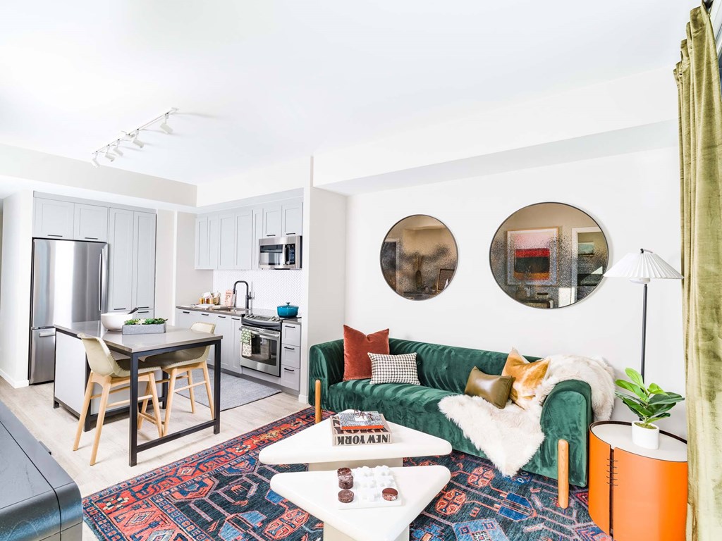 A modern living room with a green couch and a rug.