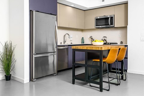 A kitchen with a table and chairs and a refrigerator.
