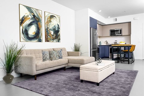 A modern living room with a couch, a coffee table, and two abstract paintings on the wall.