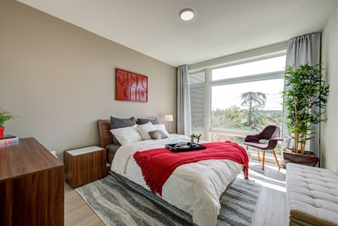A bedroom with a large bed and a red blanket.