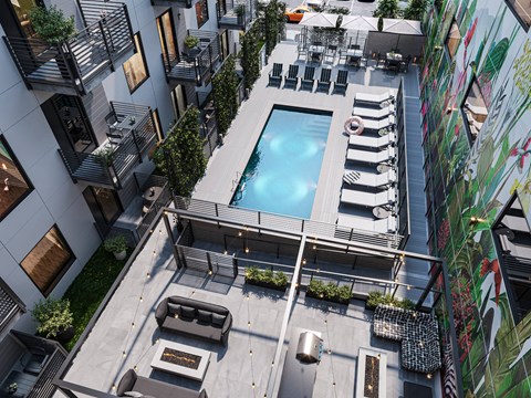A modern outdoor pool area with lounge chairs and a hot tub.