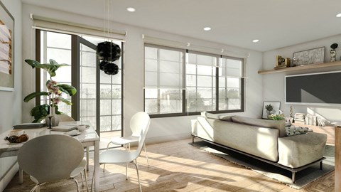 A modern living room with a white sofa and a dining table with chairs.