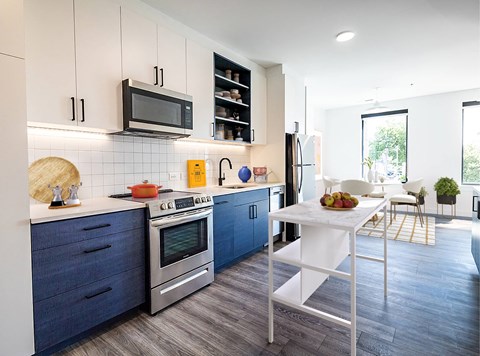 A modern kitchen with blue cabinets and a white island.