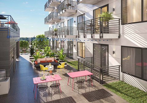 A patio with a table and chairs is surrounded by apartment buildings.