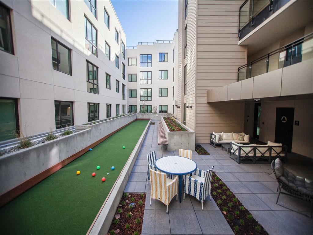 A patio with a table and chairs is surrounded by buildings.