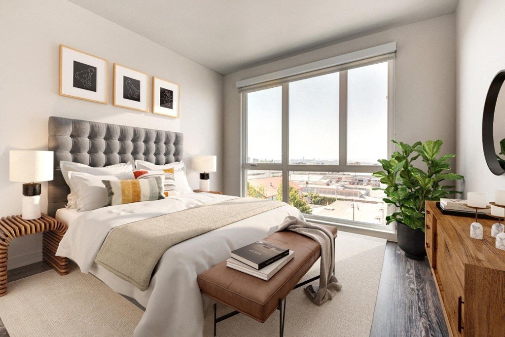 A bedroom with a large bed and a view of the city.
