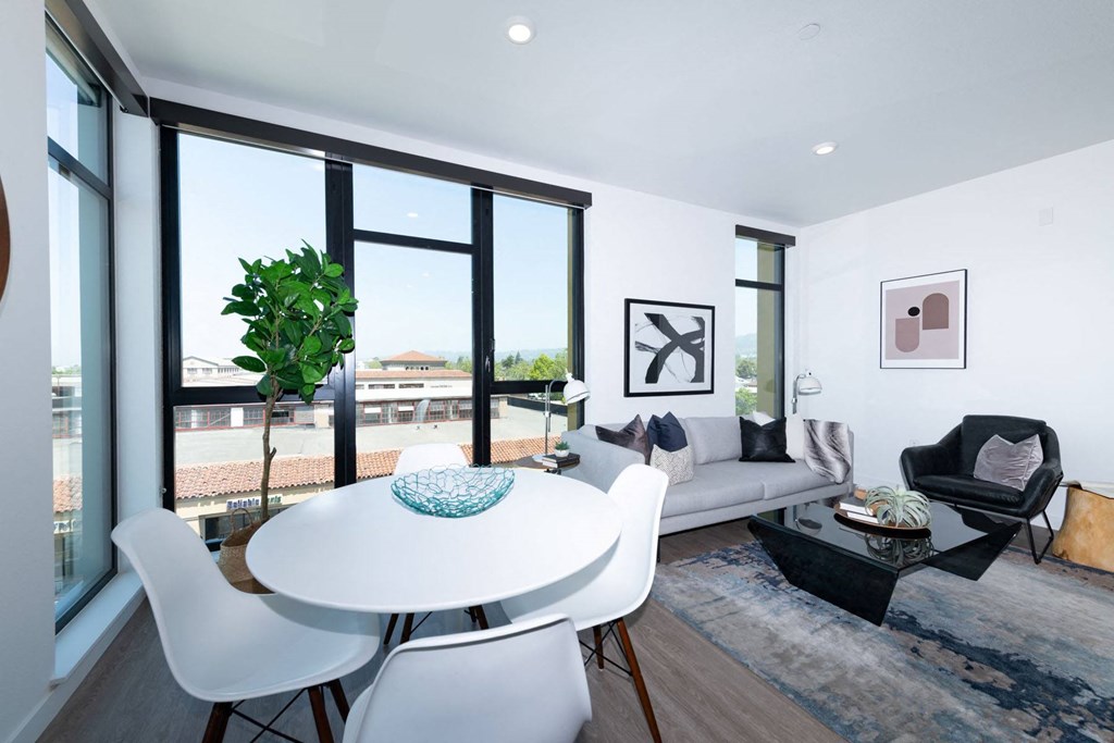 a dining area with a round white table and white chairs
