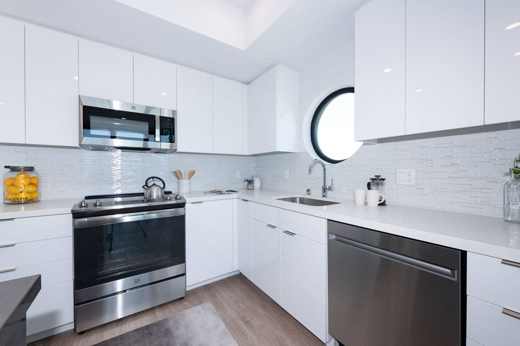 a kitchen with white cabinets and stainless steel appliances