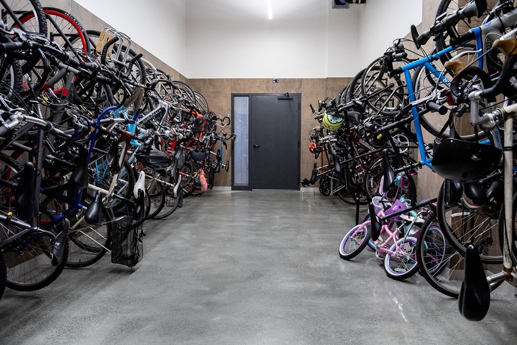 A bike storage room with many bikes on racks.
