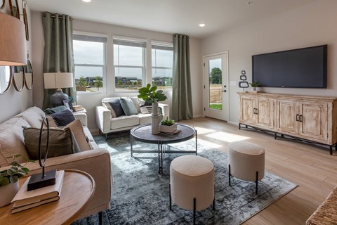 A living room with a white couch, a glass table, and a television on a wooden cabinet.