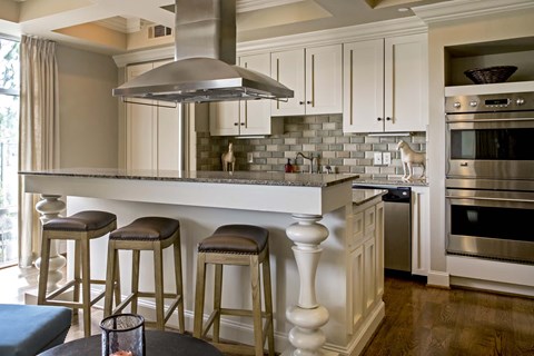 A kitchen with a bar area and a stove top oven.